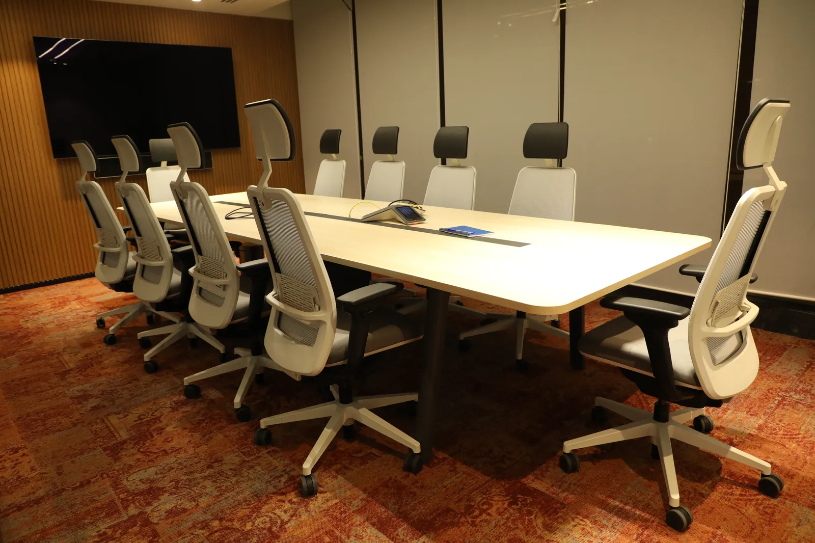 Boardroom with black chairs and smart display